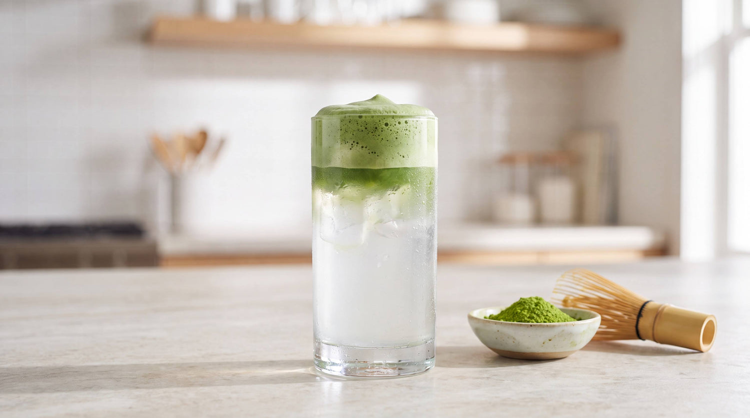 Glass of iced coconut water topped with creamy green matcha foam